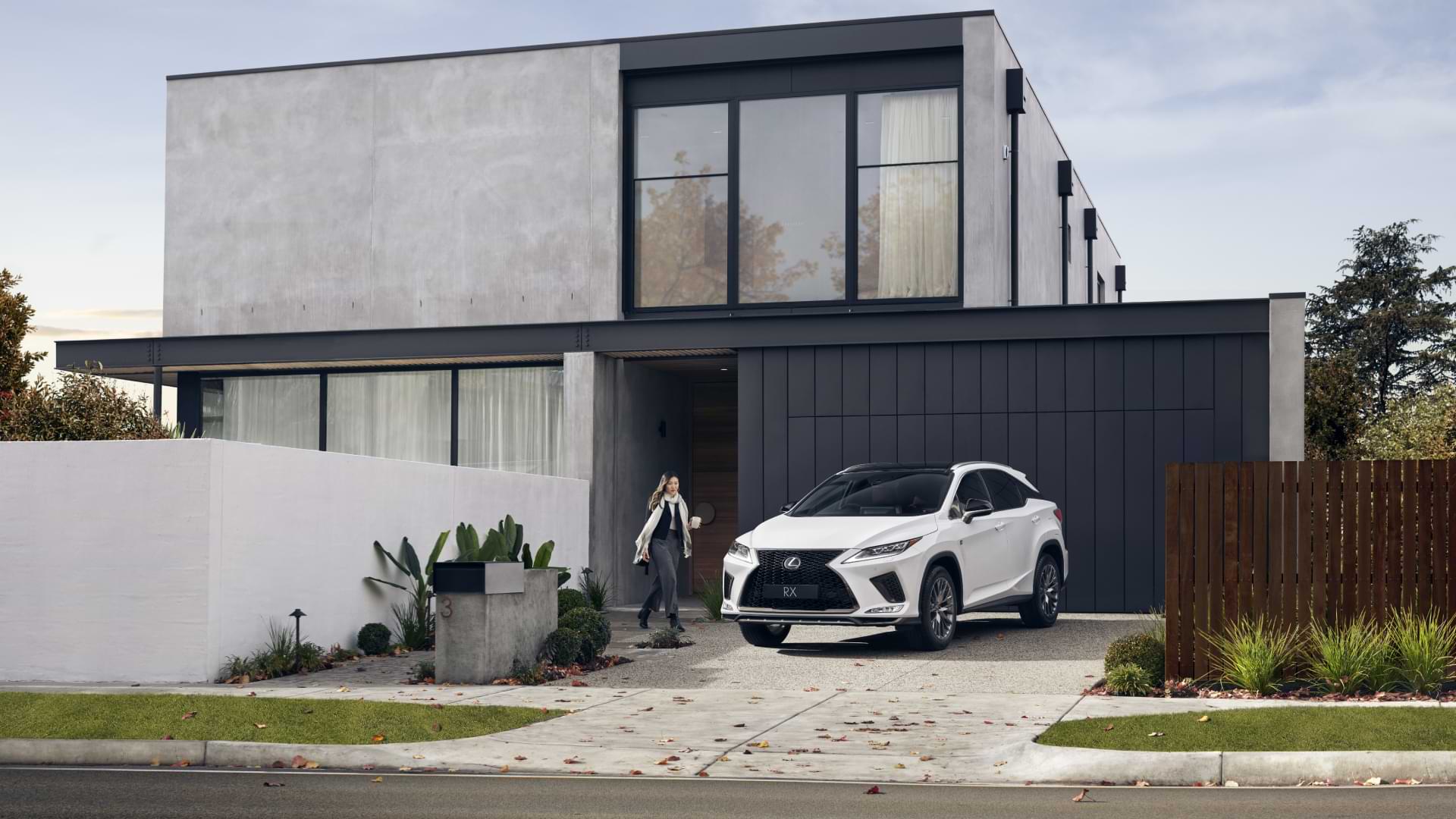 A female walking towards a Lexus SUV in her drive way